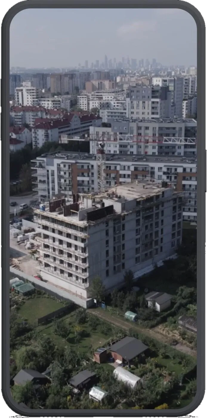 Kadr z nagrania wideo ED Invest — widok z lotu ptaka na realizowaną inwestycję mieszkaniową na tle panoramy miasta